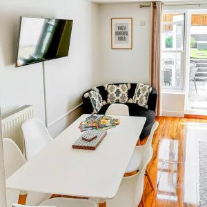 uma mesa branca e cadeiras num quarto com um sofá em 2 Bed Cottage Barnstaple North Devon Dog-Friendly! em Barnstaple