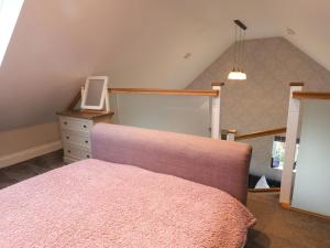 um quarto com uma cama e uma cómoda com um espelho em The Stables em Scarborough
