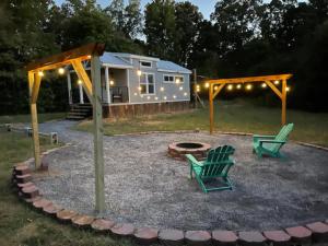 a tiny house with two green chairs and a fire pit at Charming New 1-BA/1-BR Home on an 60 Acre Property (Sleeps Up To 4) in Sardis