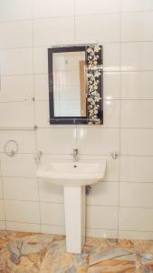 y baño con lavabo blanco y espejo. en J's Place, en Abuja