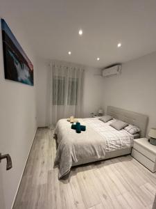 1 dormitorio con 1 cama y TV en la pared en Ravel, en Alicante