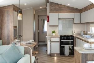 a kitchen and living room with a couch and a table at Q8 ocean edge caravan park in Heysham
