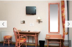 Conches-en-Ouche的住宿－Résidence Normandie，一间房间,配有一张桌子和一台墙上的电视
