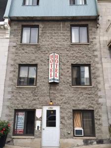 ein Backsteingebäude mit einem Schild an der Seite in der Unterkunft Hotel Victor in Montreal
