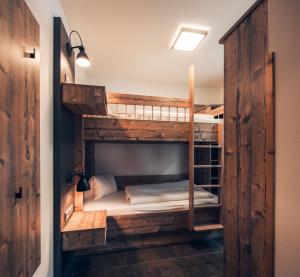 トレーポラッハにあるNassfeld-Appartementsの二段ベッドが備わる木製の壁の客室です。