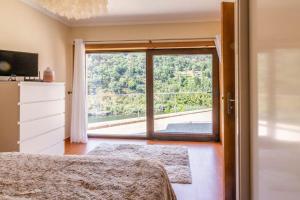 a bedroom with a large window with a view at Casa da Barragem Douro in Cinfães +40 photos