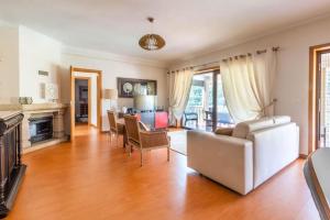 a living room with a white couch and chairs at Casa da Barragem Douro in Cinfães