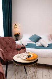 克拉科夫的住宿－Hive Family House，一张桌子,上面放着一盘食物和两杯葡萄酒