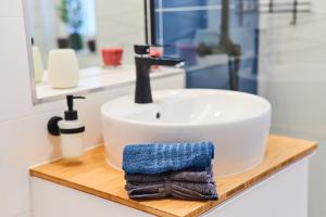 a bathroom sink with a towel on a wooden counter at Feel Home DeLuxe CORVIN # FREE PARKING # AC # Elevator in Budapest