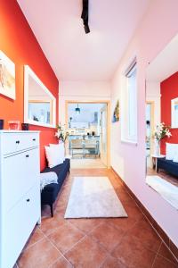 a living room with orange walls and a blue couch at FEEL HOME DeLuxe CORVIN -FREE PARKING-AC-Elevator in Budapest