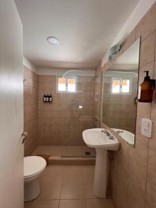 uma casa de banho com um lavatório e um WC em Departamento Tunquelen em Esquel