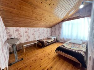 a bedroom with two beds and a wooden ceiling at Orchard in Quba