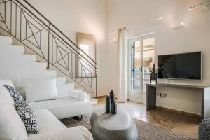 a living room with a white couch and a tv at Villa Astria in Kefallonia