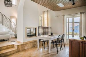 a dining room with a white table and chairs at Villa Astria in Kefallonia