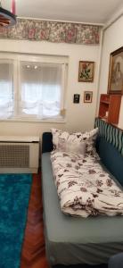 1 dormitorio con sofá y ventana con cama en Adikati Lak en Bük