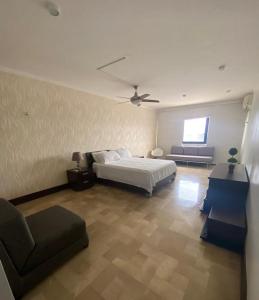 1 dormitorio con cama, sofá y ventilador en Departamento de 2 pisos Kennedy Vieja, en Guayaquil