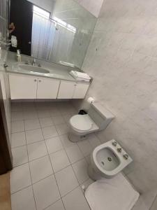 Baño blanco con aseo y lavamanos en Departamento de 2 pisos Kennedy Vieja, en Guayaquil