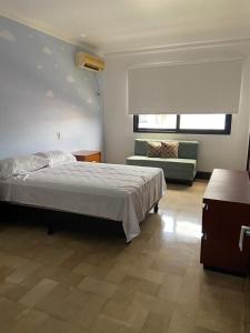 1 dormitorio con cama y sofá en Departamento de 2 pisos Kennedy Vieja, en Guayaquil