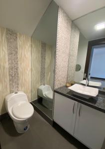 y baño con aseo y lavamanos. en Departamento de 2 pisos Kennedy Vieja, en Guayaquil