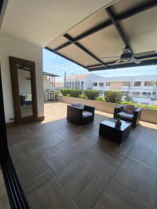a patio with couches and chairs and a mirror at Departamento de 2 pisos Kennedy Vieja in Guayaquil