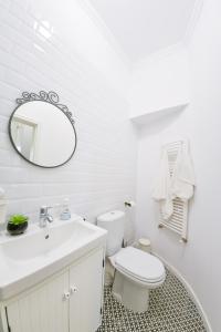 a white bathroom with a toilet and a mirror at Victoria's Old Town Deluxe Apartment in Timişoara +31 photos
