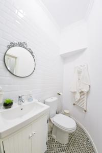 a white bathroom with a toilet and a mirror at Victoria's Old Town Deluxe Apartment in Timişoara