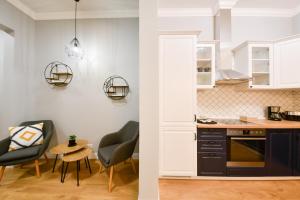 a kitchen with black cabinets and a table and chairs at Victoria's Old Town Deluxe Apartment in Timişoara