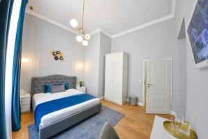 a bedroom with a blue bed and a blue rug at Victoria's Old Town Deluxe Apartment in Timişoara