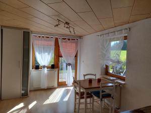 Zimmer mit einem Tisch, Stühlen und Fenstern in der Unterkunft Urlaub an der Grenze in Lauterbach