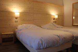 Postel nebo postele na pokoji v ubytování Hotel Rododendro Val di Fassa