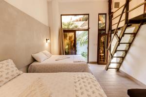 Habitación de hotel con 2 camas y escalera en Zoah Surf, El Paredón, en El Paredón Buena Vista
