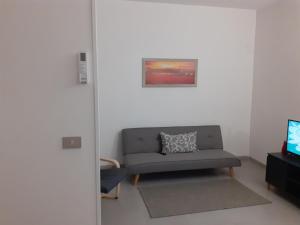 uma sala de estar com um sofá e uma televisão em Home Sweet Home em Castel SantʼElia