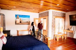 een man en vrouw op een balkon in een slaapkamer bij Hacienda Don Armando Boutique & Spa in Creel