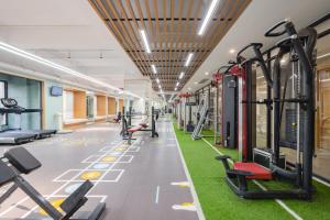 a gym with rows of tread machines and grass at Holiday Inn & Suites Suzhou Yangcheng Lake, an IHG Hotel in Suzhou