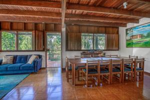 a dining room with a table and a blue couch at Finca San Tocuar in Río Cuarto