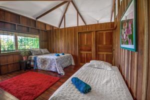 a bedroom with two beds in a room with wooden walls at Finca San Tocuar in Río Cuarto