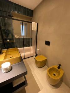 bagno con servizi igienici gialli e lavandino di Archimar House a Taranto