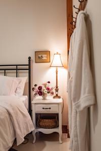 - une chambre avec un lit et une table avec une lampe dans l'établissement Rosedale Chapel Bed and Breakfast, à Steinbach