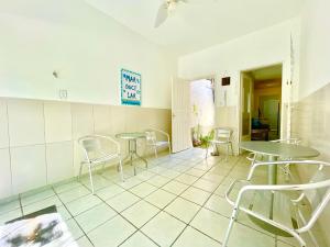a room with tables and chairs on a tiled floor at Ótima Localização casa, 7 quartos-Porto de Galinhas 900m piscinas naturais in Porto De Galinhas +33 photos