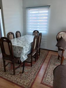 comedor con mesa, sillas y ventana en Casa a 5 minutos del balneario en Frutillar