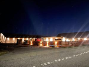 a barn with lights on the side of it at night at Stor rummelig lejlighed med egen P-plads in Kolding