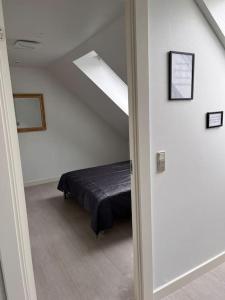 1 dormitorio con 1 cama en una habitación blanca en Stor rummelig lejlighed med egen P-plads en Kolding