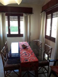 a dining room with a table and chairs and windows at Chalet La Floresta in La Floresta
