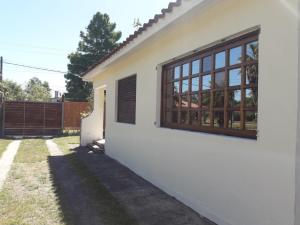 une maison blanche avec une fenêtre et une clôture dans l'établissement Chalet La Floresta, à La Floresta