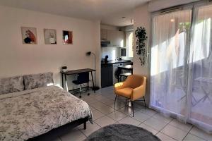 um quarto com uma cama, uma mesa e uma cozinha em Studio charmant et moderne grand confort em Toulouse