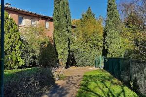 um quintal com uma cerca e árvores e uma casa em Studio charmant et moderne grand confort em Toulouse