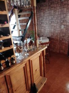 bodega con copas de vino en un armario de madera en Nuestro Hogar en Malargüe
