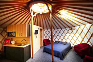 1 dormitorio en una yurta con cama y lavamanos en Glamping Dolina 