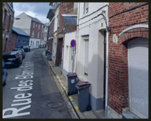 een lege straat met een straatbord aan de zijkant van een gebouw bij L'échappée belle pour 5 in Saint-Quentin