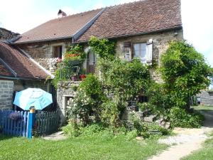 a house with an umbrella in front of it at La maison du Gué in Écutigny